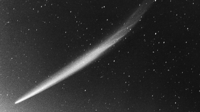 the white streak of a comet stretches from lower left to upper right, against a black sky full of stars. Comet Ikeya-Seki was the brightest comet of the 20th century and was at one point visible in broad daylight right next to the sun. This image was taken on October 30, 1965 and shows the full extent of this large comet's tail of about 30 degrees.