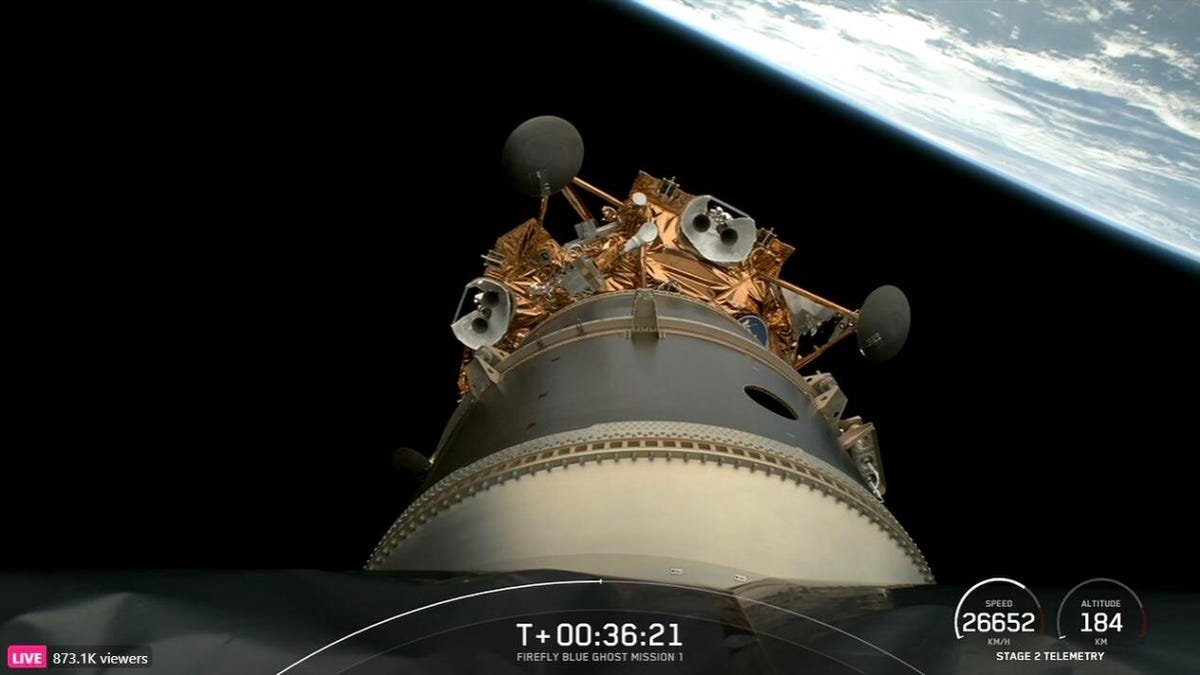 A copper-hued lunar lander at the end of a space capsule in orbit, with Earth horizon in the background