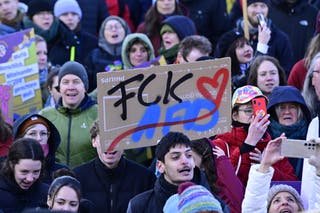 A demonstrator holds a poster reading 