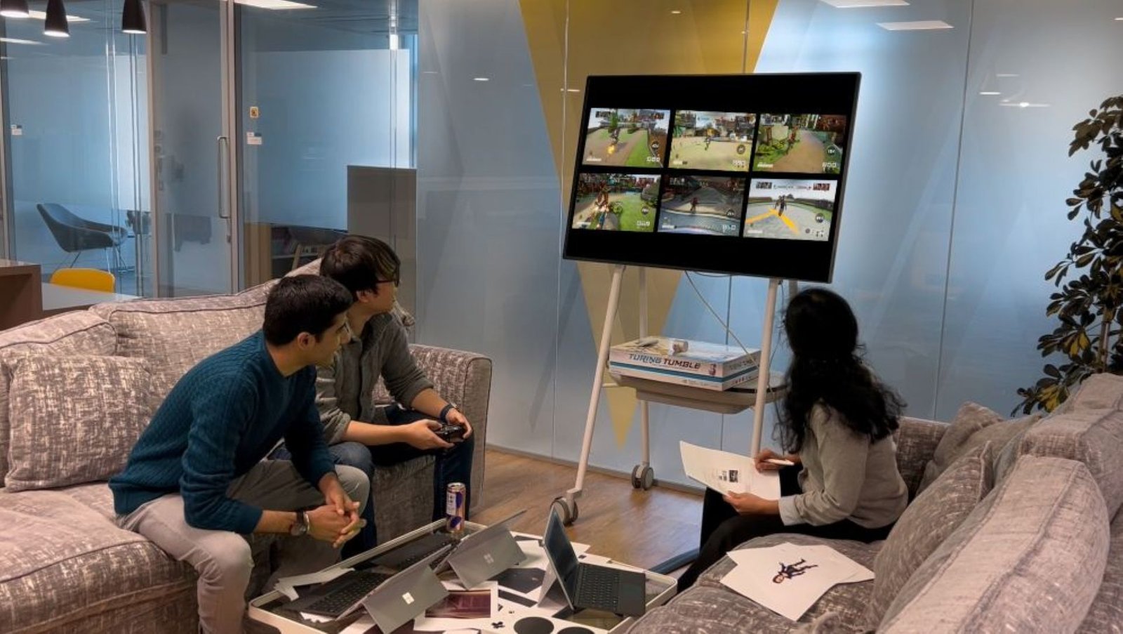 Three people playing a video game on a big screen.