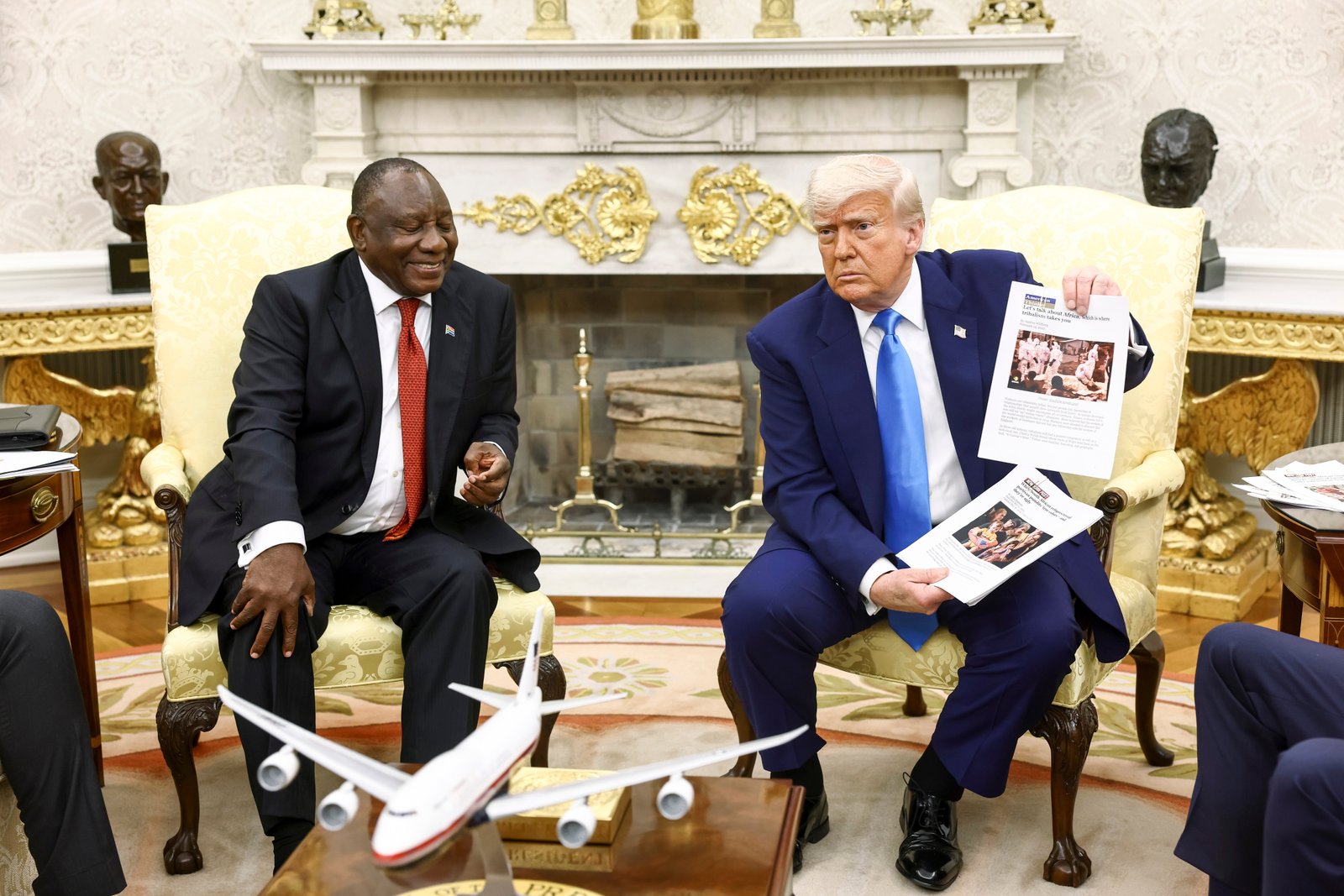 US President Donald Trump (R) holds news articles related to violence in South Africa during a meeting with the country's President Cyril Ramaphosa (L), in the oval office