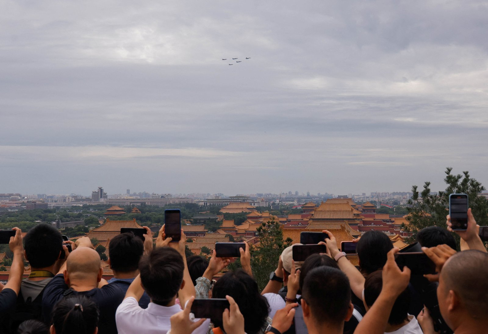 People take pictures of a formation of military aircraft flying over the roofs of the forbidden city during a flypast -General Test