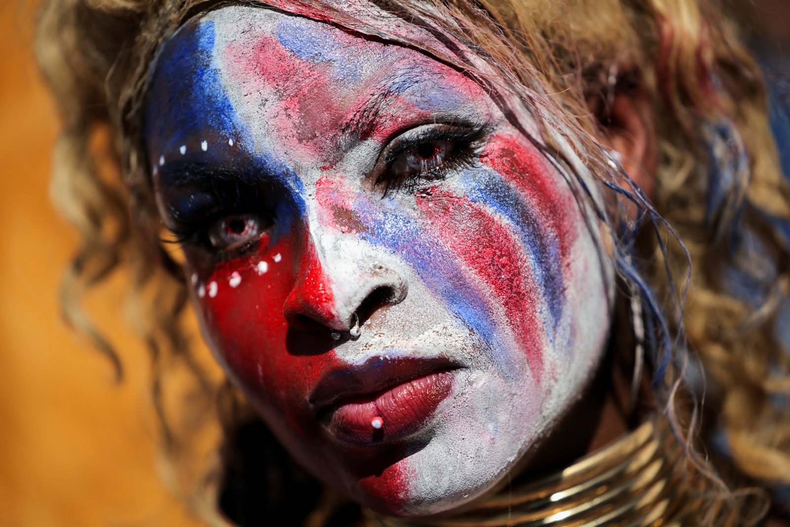 A protester wearing makeup in the colors of the American flag at a demonstration outside City Hall in Los Angeles, California
